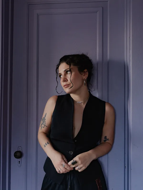 Jenna Rose Marti stands in front of a door looking towards the left