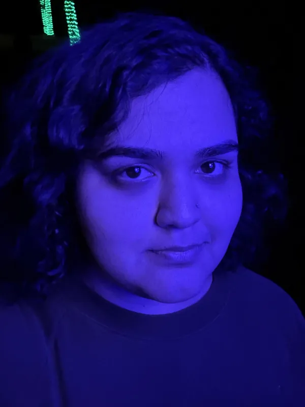 a person with dark hair stares into the camera